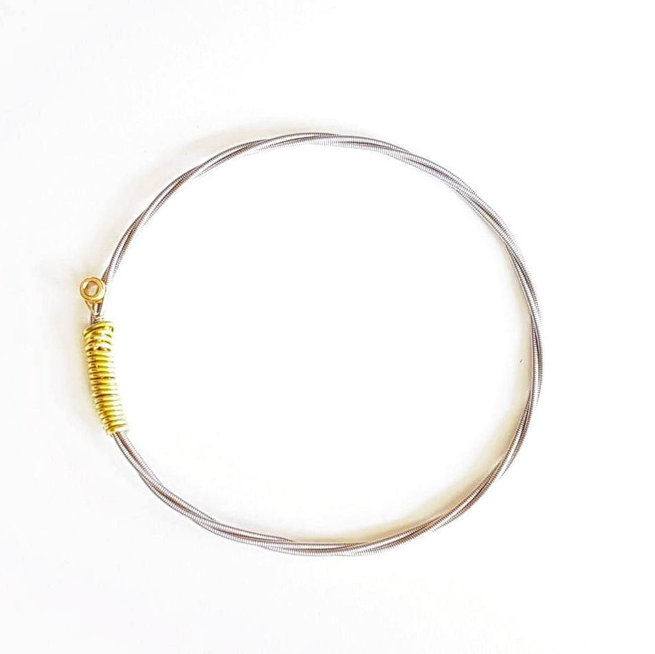 bangle style bracelet made from an upcycled guitar string - white background