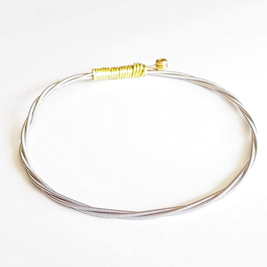 bangle style bracelet made from an upcycled guitar string - white background
