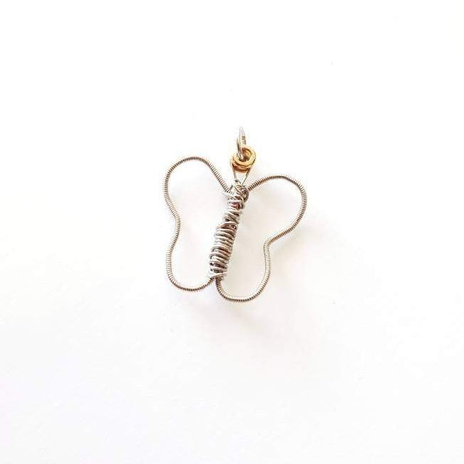 a pendant made from an upcycled guitar string shaped into a butterfly -  white background