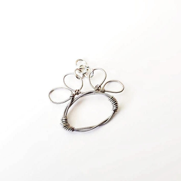 paw print pendant made from an upcycled guitar string - white background