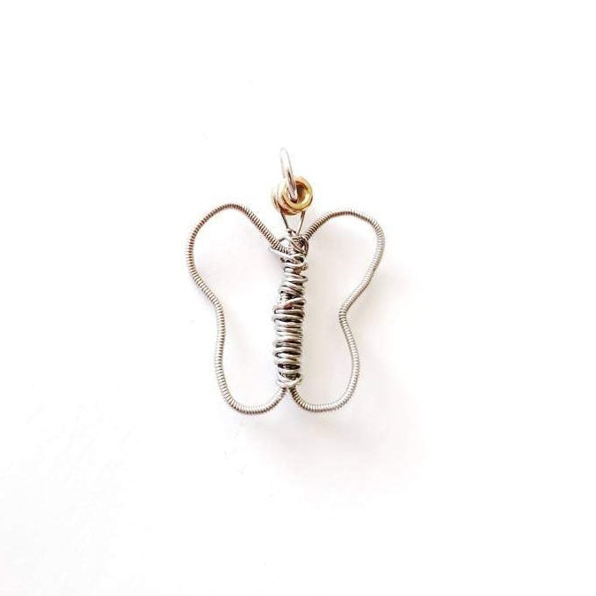 a pendant made from an upcycled guitar string shaped into a butterfly - white background