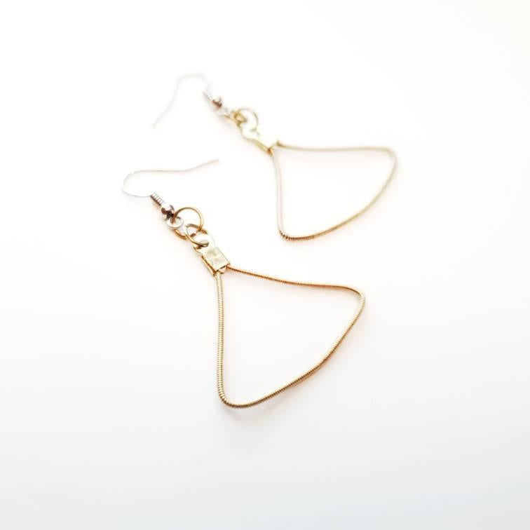 a pair of gold coloured earring made from an upcycled guitar string in the shape of a triangle 