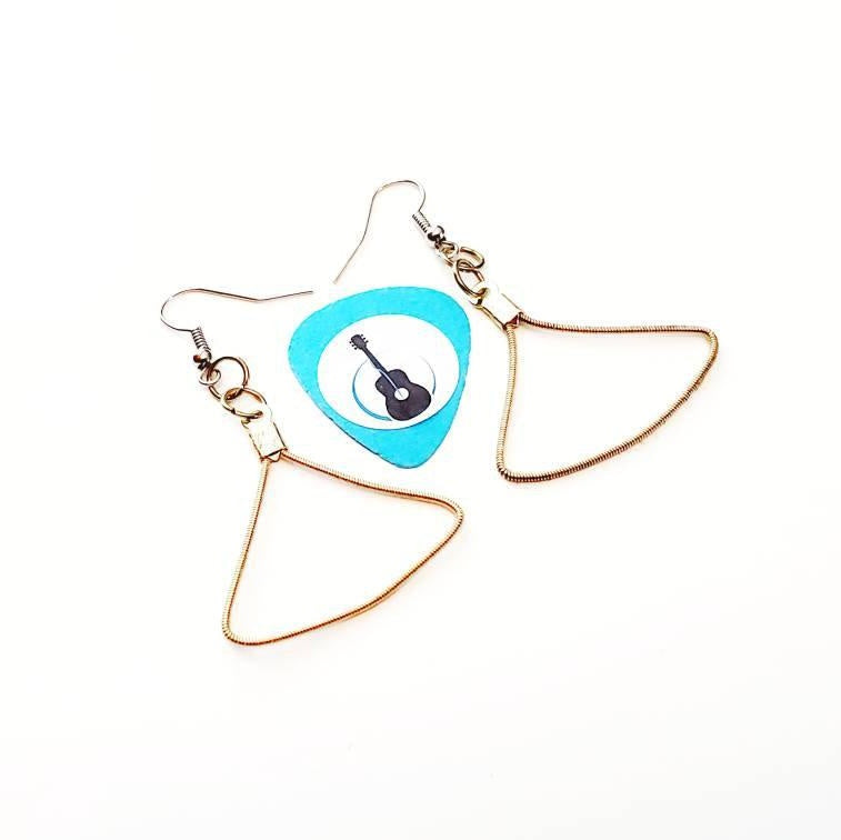 a pair of gold coloured earring made from an upcycled guitar string in the shape of a triangle in the middle of the pair is a blue guitar pick with an image of a black guitar - white background